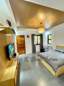 a bedroom with a bed and a flat screen tv at M11 Z Guest House in Pasuquin