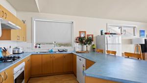a kitchen with a blue counter top and a refrigerator at Sheoak Holiday Home in Coffin Bay
