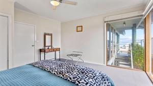 a bedroom with a bed and a large window at Sheoak Holiday Home in Coffin Bay +12 photos