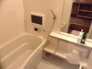 a bathroom with a tub and a toilet and a television at Nagomi Ryokan Yu - Vacation STAY 81037v in Kyoto