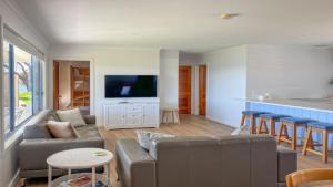 a living room with a couch and a table and a kitchen at Wrightaway in Coffin Bay