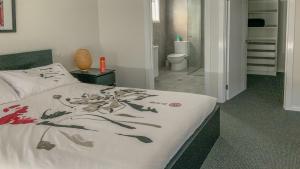 a bedroom with a bed with a painting on it at Grey On The Bay in Coffin Bay +11 photos