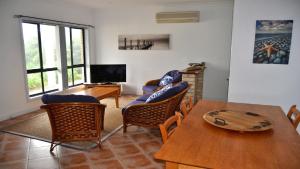 a living room with a table and chairs and a television at Coffin Bay Retreat in Coffin Bay