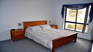 a bedroom with a bed and a window at Coffin Bay Retreat in Coffin Bay