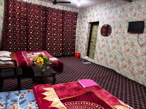 a room with a bed and a table with flowers on it at Aziz Guest House Near dal lake in Srinagar