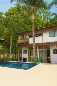 ein Resort mit einem Swimmingpool und einem Gebäude in der Unterkunft Perequê Vilarejo Ilhabela in Ilhabela