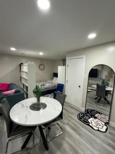 ウィニペグにあるElegant & Stylish Basement Suite- Private Entranceのテーブルと椅子のあるリビングルームと寝室