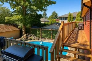 a deck with a pool and a grill next to a house at Charming "Melrose Place" w Year-Round Heated Pool, Deck & Grill in Victoria