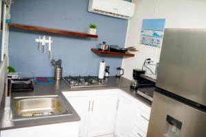 une cuisine avec un évier et une cuisinière dans l'établissement SunSal Garden Surf Hub, à El Sunzal 42 autres photos