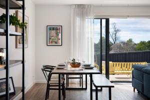 a dining room with a table and chairs and a balcony at Bluestone Haus - stylish home in Daylesford