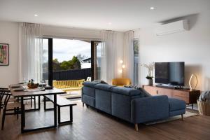 a living room with a blue couch and a table at Bluestone Haus - stylish home in Daylesford