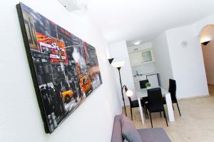 una pintura colgada en una pared en una sala de estar en AQUAMARINA C HomeStay By Turismar, en La Pineda