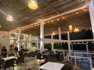 a restaurant with tables and chairs and lights at Coco Bay Hon Son in Lai Sơn