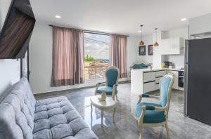 a living room with a couch and chairs and a kitchen at Apartahotelquimbaya in Quimbaya