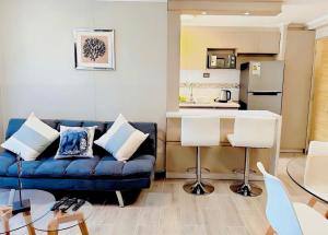 a living room with a blue couch and a kitchen at Departamento cerca del mar con 3 habitaciones in Arica