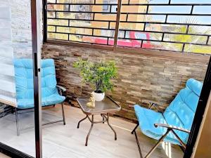 a patio with two chairs and a table with a potted plant at Departamento cerca del mar con 3 habitaciones in Arica