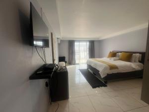 a bedroom with a bed and a flat screen tv at Grace Boutique Guest House in Manamakgoteng