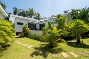 a house with palm trees in front of it at Bougain Villas in Salad Beach
