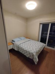 Un dormitorio pequeño con una cama y una ventana. en Panoramic view apartment, en Lima