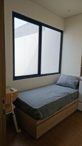a bed in a room with two large windows at Seffa living bsd Jakarta in Cilenggang +13 photos