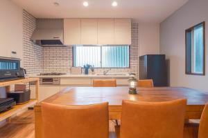 a kitchen with a wooden table and chairs at rinne 九十九里 Beachhouse in Katakai