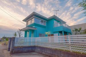 a blue house with a fence in front of it at rinne 九十九里 Beachhouse in Katakai +40 photos