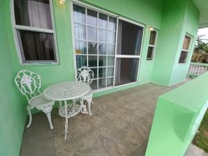 a patio with a table and chairs on a green house at Nested View in Westerhall Land Settlement