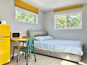 a small bedroom with a bed and a table and a desk at Twin Stay1 in Yonghwa