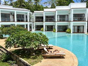 two women laying on chaises by the swimming pool of a hotel at Resort Deja Vu in Siquijor