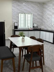 a kitchen with a table and some chairs and a counter at Lock homestay in Kulai