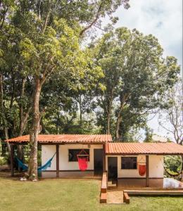 a house with a hammock and a playground at Cabañas La Pradera in Buena Vista
