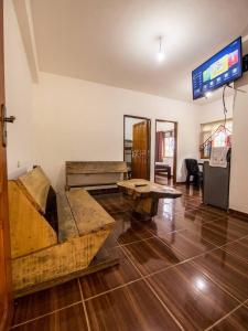 a living room with wooden tables and a tv at Cabañas La Pradera in Buena Vista