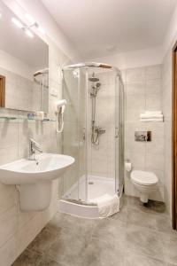 uma casa de banho com um chuveiro, um lavatório e um WC. em Zulian Aparthotel by Artery Hotels em Cracóvia