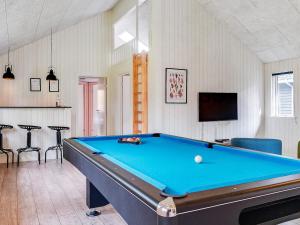 a pool table in a living room with a pool at 18 person holiday home in Væggerløse in Marielyst