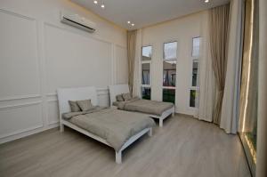 a bedroom with two beds and a large window at AlNouf Chalet in Barka +38 photos