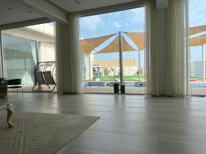 a large room with a large window and a pool at AlNouf Chalet in Barka