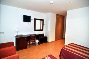 a living room with a desk and a chair at Norte Hotel in Villanueva de Gállego