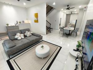 un salon avec un canapé et une table dans l'établissement Spacious, 2 Storey Home, Up to 12 Pax, 4 Bedrooms, 4 Bathrooms, 2 Car Park Lots by Star Home, à Sungai Petani