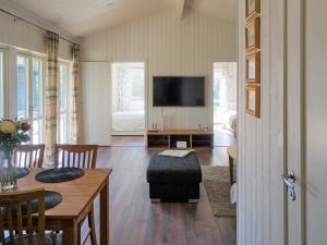 een woonkamer met een televisie en een tafel en stoelen bij 5 person holiday home in SÖLVESBORG-By Traum in Sölvesborg