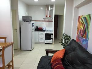 a living room with a couch and a kitchen at Apartamento Entre Olivos in Mendoza +3 photos