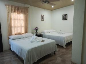 two beds in a room with white sheets at Hotel El Internacional in Granada +24 photos