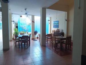 a dining room with tables and chairs and a blue wall at Hotel El Internacional in Granada