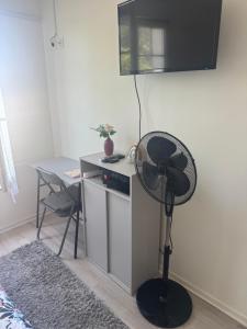 a room with a desk with a fan and a table at Studio lumineux avec WiFi gratuit Centre Antony, accès rapide Paris & Orly in Antony