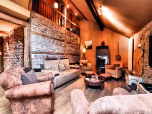 ein Wohnzimmer mit Möbeln und einer Steinmauer in der Unterkunft Relaxing Retreat Near Forests in Oppagne