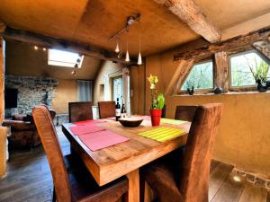 ein Esszimmer mit einem Holztisch und Stühlen in der Unterkunft Relaxing Retreat Near Forests in Oppagne