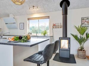a stove in a kitchen with a table and chairs at 5 star holiday home in Grenaa in Grenå