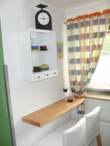 a room with a table and a clock on a wall at Ferienwohnung Anne in Sankt Ulrich am Pillersee