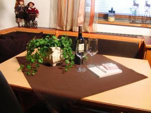 ザンクト・ウルリッヒ・アム・ピラーゼーにあるFerienwohnung Anneのワイン1本とグラス2杯付きのテーブル