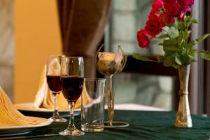 uma mesa com dois copos de vinho e um vaso de rosas em Hotel Terazini em Veliko Tŭrnovo