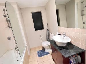 a bathroom with a sink and a toilet and a shower at Authur's 2 bedrooms apartment, balcony, wifi, parking, cot, sunny, washing machine drier in Auckland